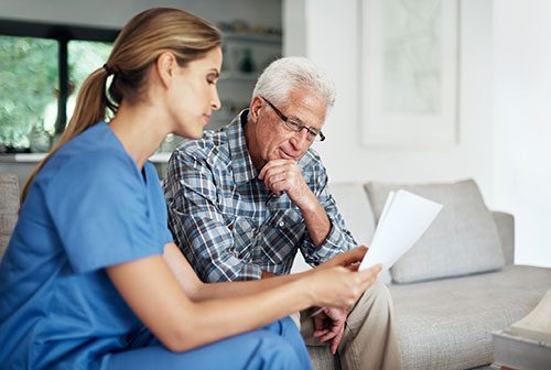 Medic discussing information with patient on sofa