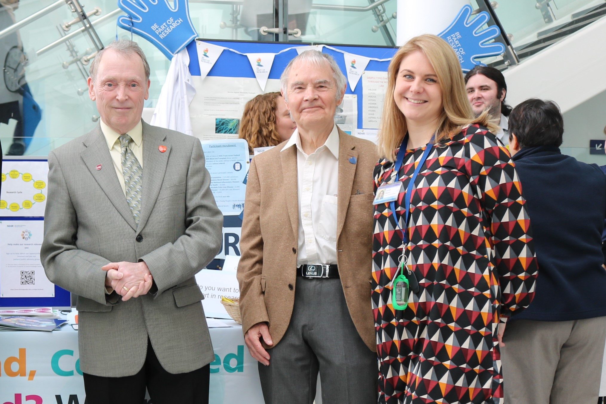 Public contributors of the NIHR Birmingham BRC standing in front of the stand at Queen Elizabeth Hospital with Project Manager