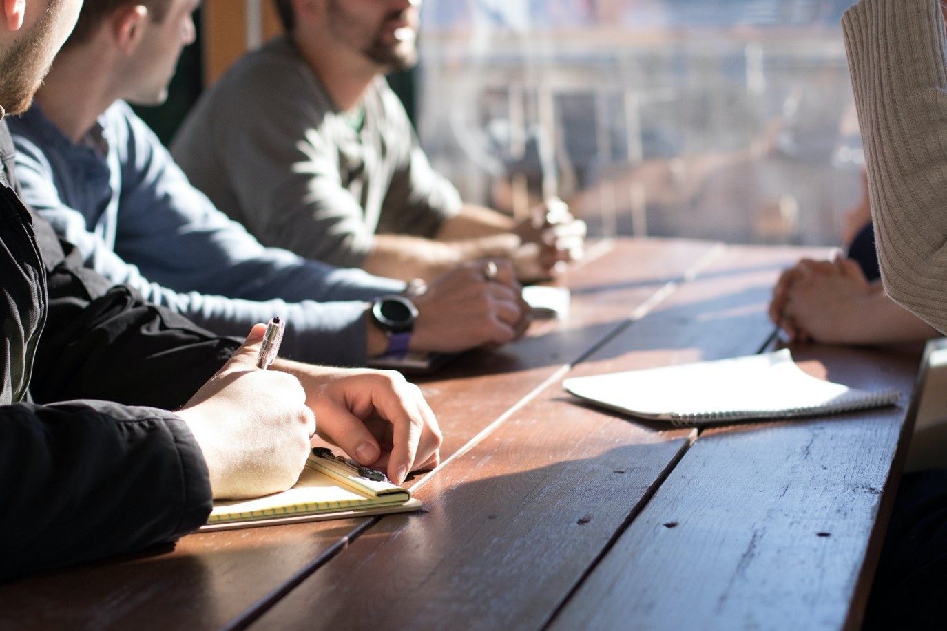 People having a conversation and taking notes at a table