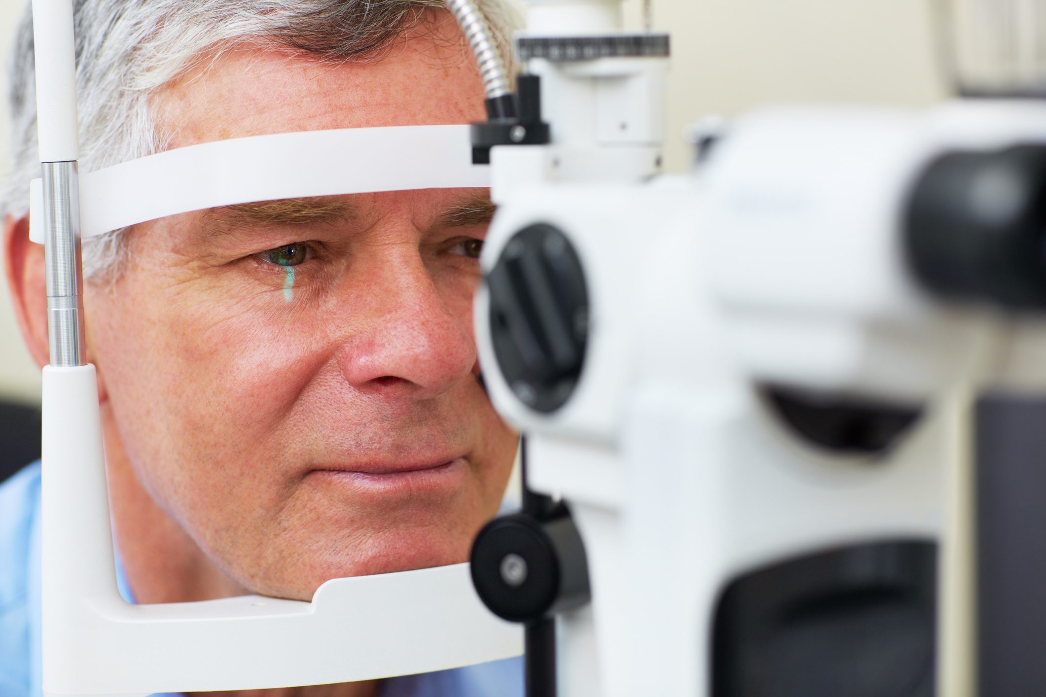Middle aged man undergoing an eye test with equipment