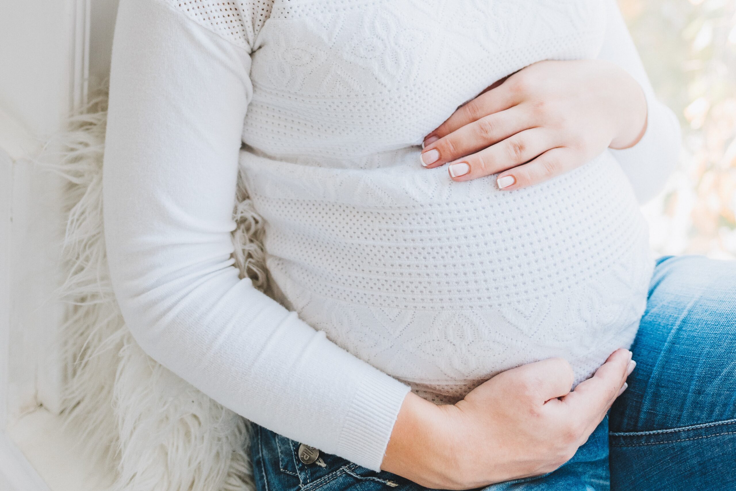 Pregnant woman placing her hands on her tummy