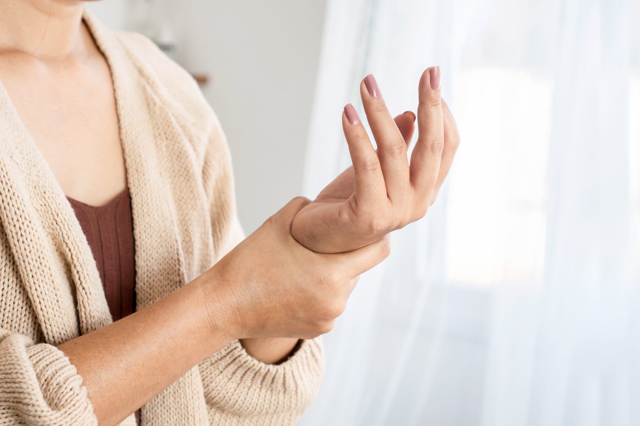 Woman holding painful wrist with arthritis