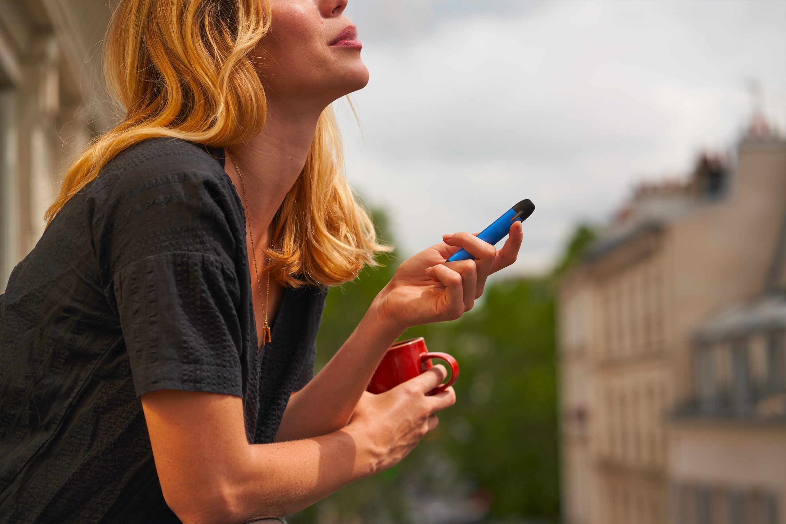 Woman vaping on a balcony