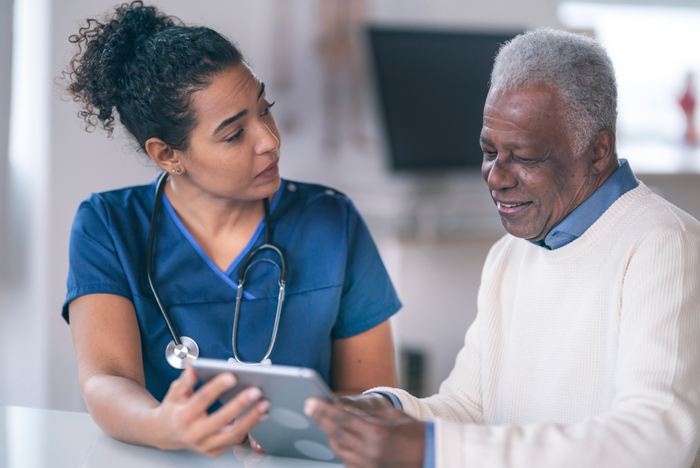 Medic in discussion with patient showing information on a clipboard