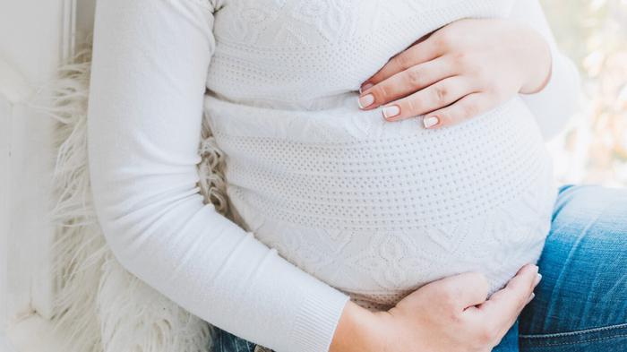 Pregnant woman pressing hands against stomach