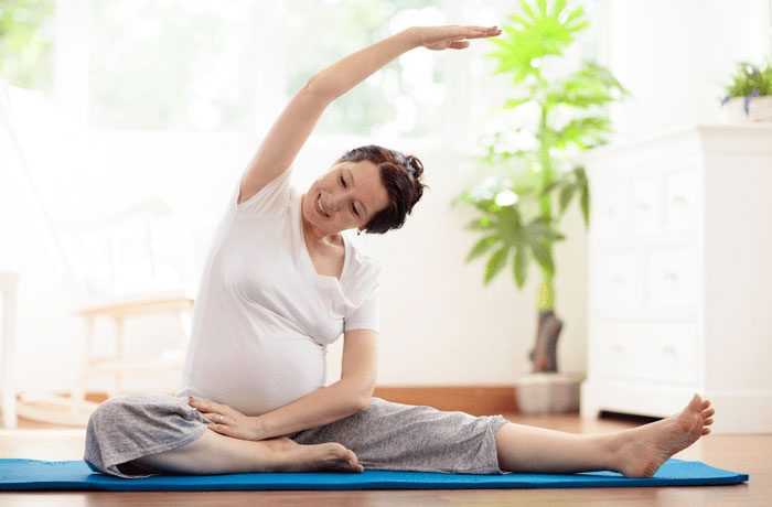 Woman sat on exercise mat stretching