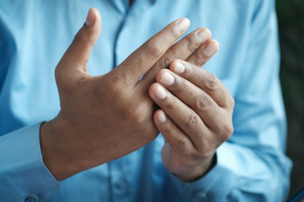 Person holding clasping one hand with the other