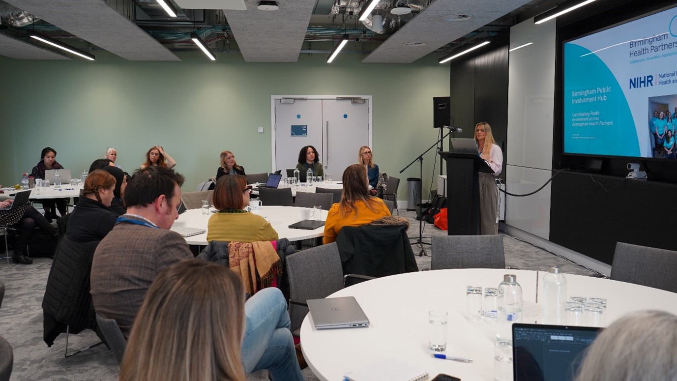 Room of attendees with Lucy Oakey presenting on stage