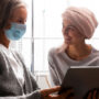 Patient wearing face mask and in discussion with another patient