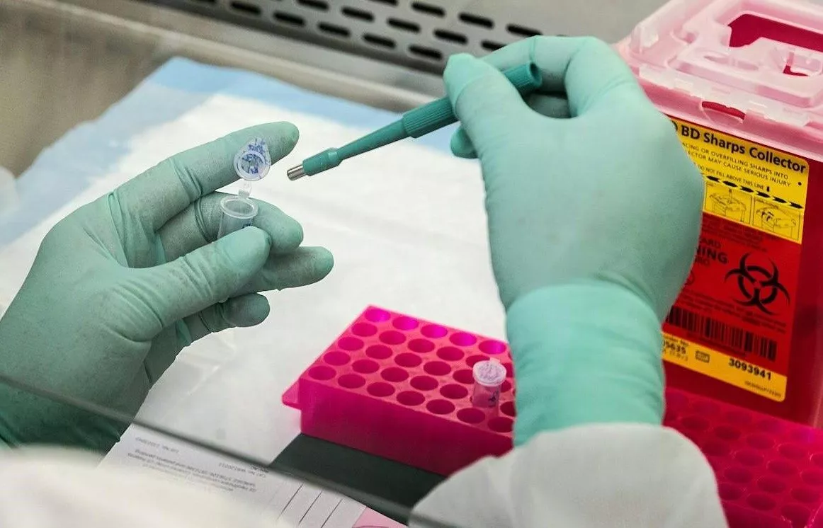 Scientist in a lab using pipette and test tube
