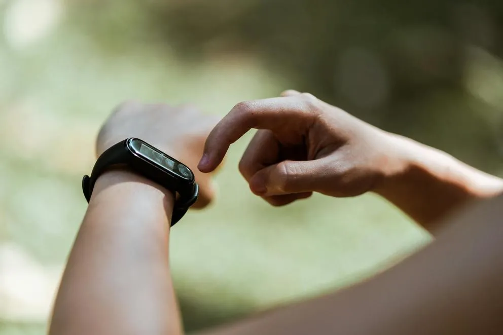 Person looking at their wearable fitness tracker on their wrist