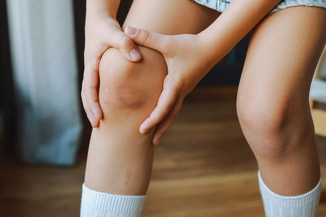 Child holding painful knee
