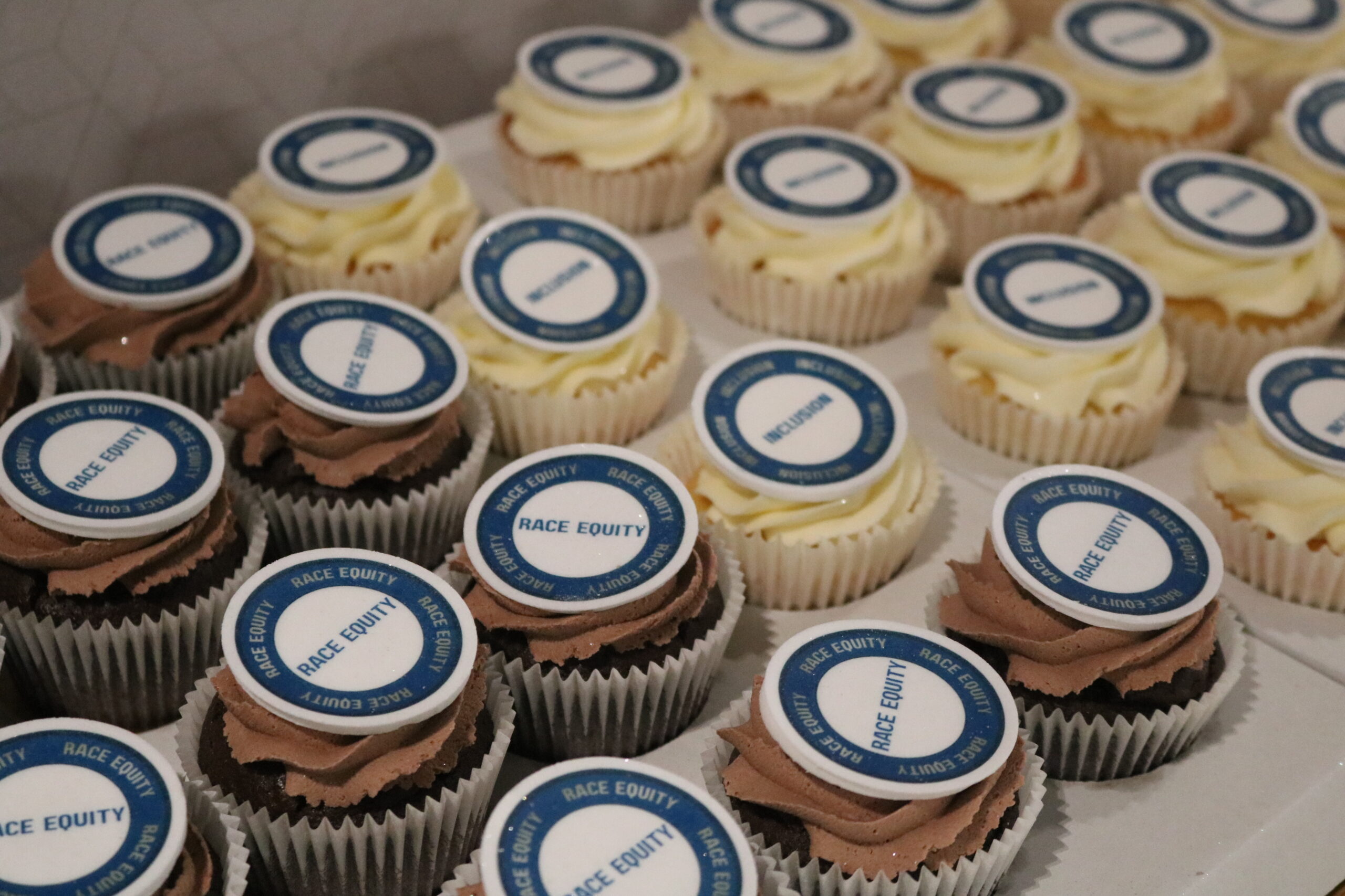 Cupcakes with icing that says 'race equity'