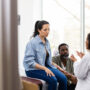 Fertility doctor consulting a couple, holding a syringe